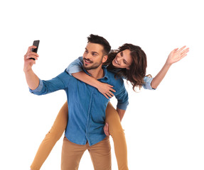 Fototapeta na wymiar woman on the back of man while he takes selfie