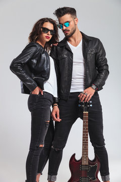 sexy couple in leather jackets holding electric guitar
