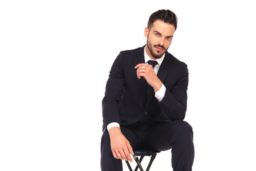cool young business man sitting on a chair