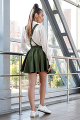 Obraz premium Portrait of a beautiful young girl outdoors in the city, standing in clothes