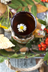 Obraz na płótnie Canvas glass of hot tea with autumn leaves