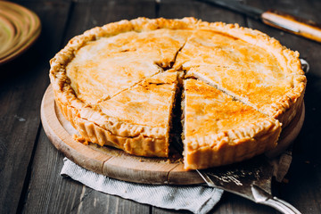 Fresh Meat pie on the wooden board on table background. Pie with cabbage and minced beef