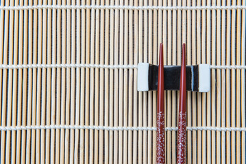 Top view chopsticks on bamboo mat .