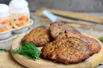Home chicken liver pancakes with vegetables on a wood board. Fried chicken liver pancakes with carrot and onion. Cooking liver. Rustic style. Closeup