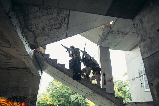 soldier with a rifle in an abandoned building. Fighting, explosion, smoke