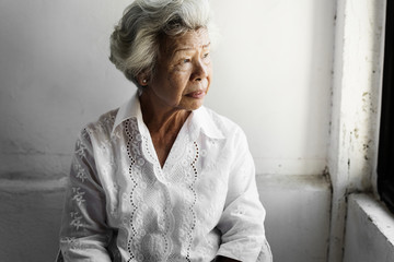 Side view of elderly asian woman with thoughtful face expression - obrazy, fototapety, plakaty