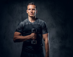 A man holds a set of dumbbells.