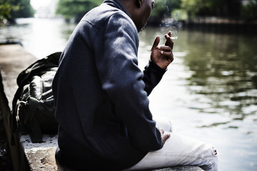 African descent man sitting by the river