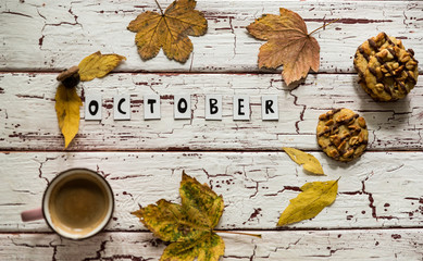 Close up of yellow leaves and corns on rustic white wooden background. Cup of coffee americano with...