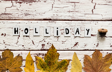 Close up of yellow leaves and corns on rustic white wooden background. Cup of coffee americano with...