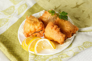 fish in batter with greens on a white plate