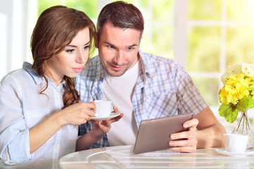 Obraz na płótnie Canvas young couple looking at digital tablet