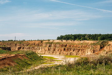 Open-cast quarry, limestone mining, orange sand and clay mountains