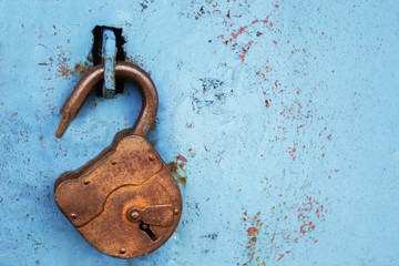 Old rusty lock without a key on a blue background