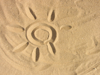 Fototapeta na wymiar playing with sand on the beach (sun shape)