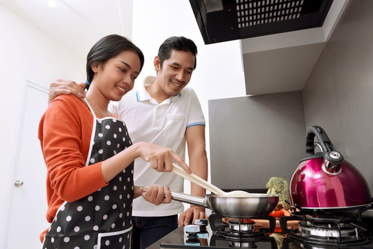 Portrait of asian couple smiling and cooking together