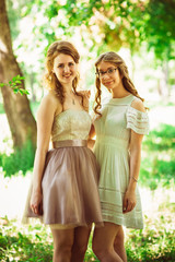 Naklejka premium Two beautiful girlfriends on a plant background