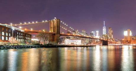 Fototapeta na wymiar Brooklyn Bridge over East River at night in New York City Manhattan with lights and reflections.