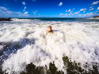Fototapeta premium teenager having fun in the sea waves - summertime - Sicily mediterranean sea