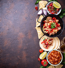 Concept of Mexican food.  Salsa, tortilla, beans, fajitas and tequila
