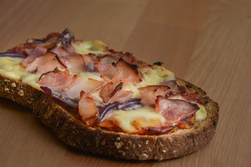 Delicious seasoned savory Italian tomato bruschetta slices on a rustic wooden board garnished with fresh basil leaves.