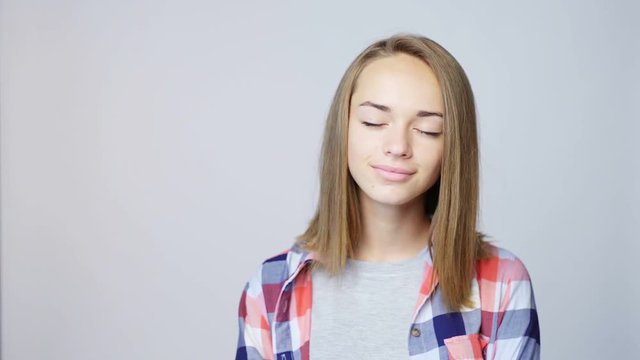 Closeup portrait of teen girl in casual clothing enjoying imagining with closed eyes