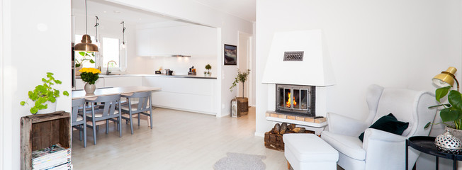 banner of a fancy living room and kitchen with lit fire in fireplace