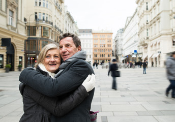 Fototapeta na wymiar Senior couple on a walk in city centre. Winter