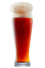 Mug of frosty dark red beer with foam isolated on a white background