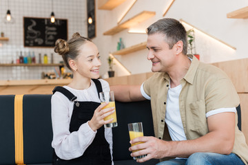 father and daughter with orange juice