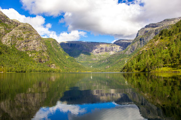 Naklejka na ściany i meble Beautiful mountain lake with mirrored reflection in Norway