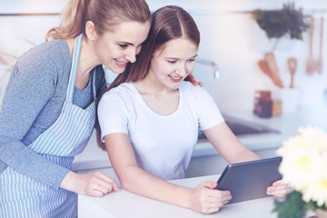 Loving mom embracing her teenage daughter in kitchen