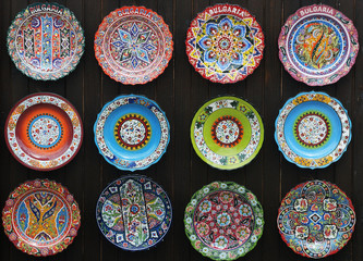 Colorful souvenirs hand painted ceramic plates on the wall in the bulgarian market