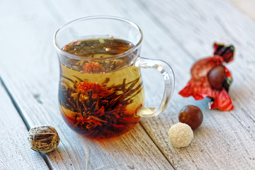 Green chinese tea flower bud blooming in glass tea cup. Morning breakfast. shallow depth of field.