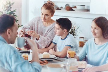 Thoughtful mother taking care of family during breakfast
