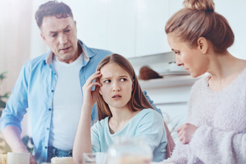 Scared parents discussing misbehavior of their daughter