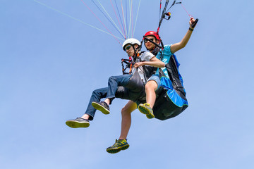 Fototapeta na wymiar Instructor and paraglider flying in sky