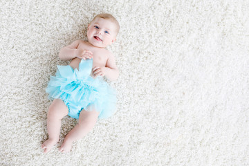 Adorable baby girl on white background wearing turquoise tutu skirt. © Irina Schmidt