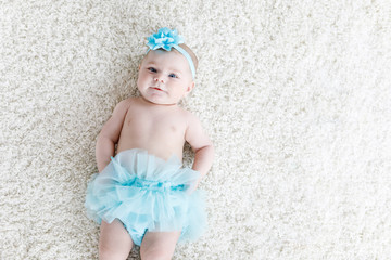 Adorable baby girl on white background wearing turquoise tutu skirt. © Irina Schmidt