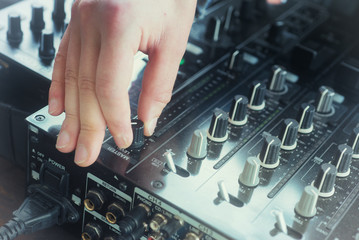 Hand adjusting audio mixer on concert and sound record