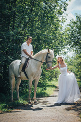 Man, bride and white horse in the park