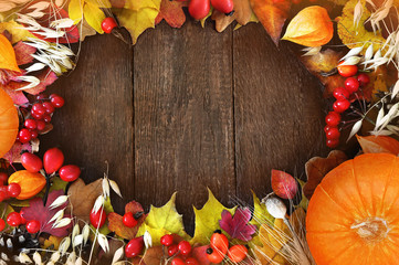 Autumn leaves on wooden background, fall leaf thanksgiving frame with orange pumpkin, toned