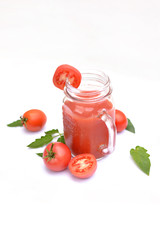 Sliced tomatoes and fresh tomato juice in a glass jar.