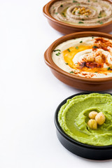 Different hummus bowls. Chickpea hummus, avocado hummus and lentils hummus isolated on white background
