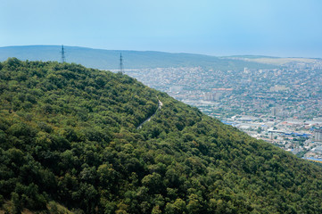 Obraz premium Aerial view of the green hill on the background of the city and the sea. Black Sea, Russia