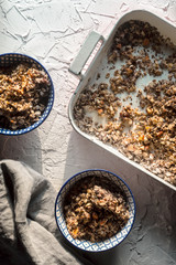 Form for baking, bowls with granola and napkin on white table