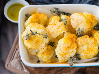 Baked cauliflower with turmeric and marjoram on rustic background. Lunch with vegetables
