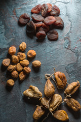 Dry figs, yellow and brown dried apricots on a gray stone