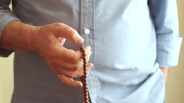 Man Counting Prayer Beads