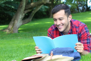 Cheerful student reading in the park